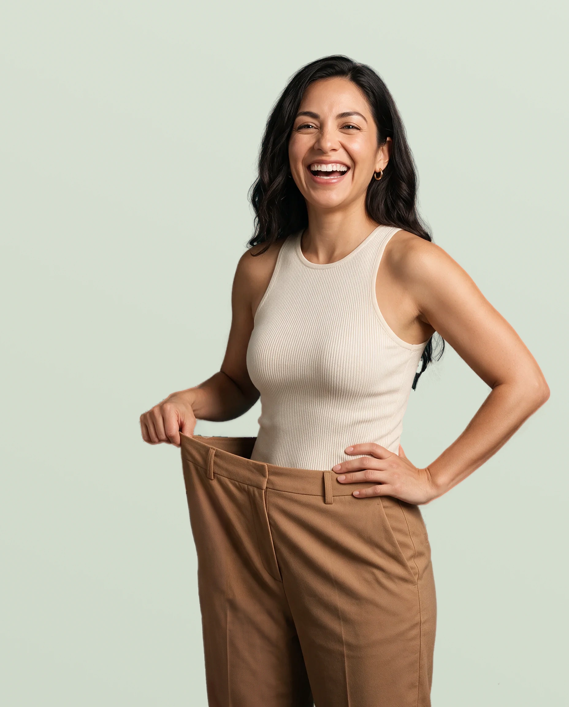 Illustrative model smiling and holding the waist of her trousers